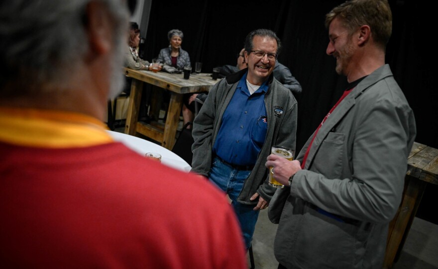 Emilio Valdez (center) speaks with congressional candidate Erik Aadland at Rails End Beer Co. on Jan. 28. Valdez, a Republican voter, said he likes to know what candidates stand for before signing petitions in support of them.