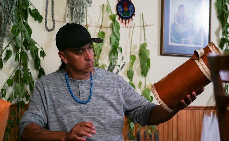 Biskakone Greg Johnson decorates a birch bark basket