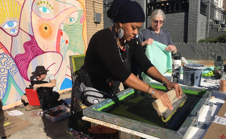 Crystal Clarity, an art director for the march, teaches volunteers how to screen-print posters for the march.