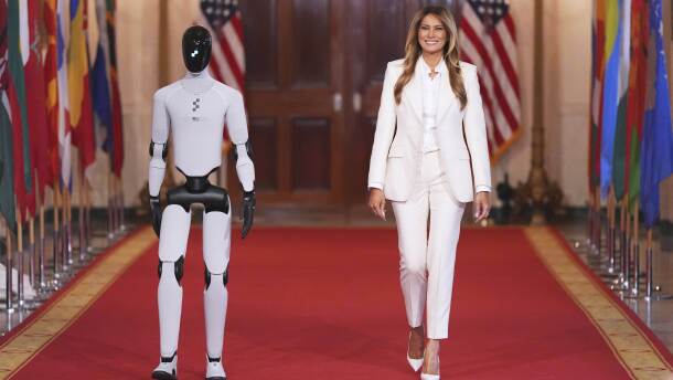 First lady Melania Trump arrives, accompanied by a robot, to attend the "Fostering the Future Together Global Coalition Summit," with other first spouses, at the White House, Wednesday, March 25, 2026, in Washington.