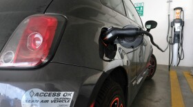 This April 25, 2016 file photo shows an electric Fiat plugged into a charging station in a parking lot in Los Angeles. 