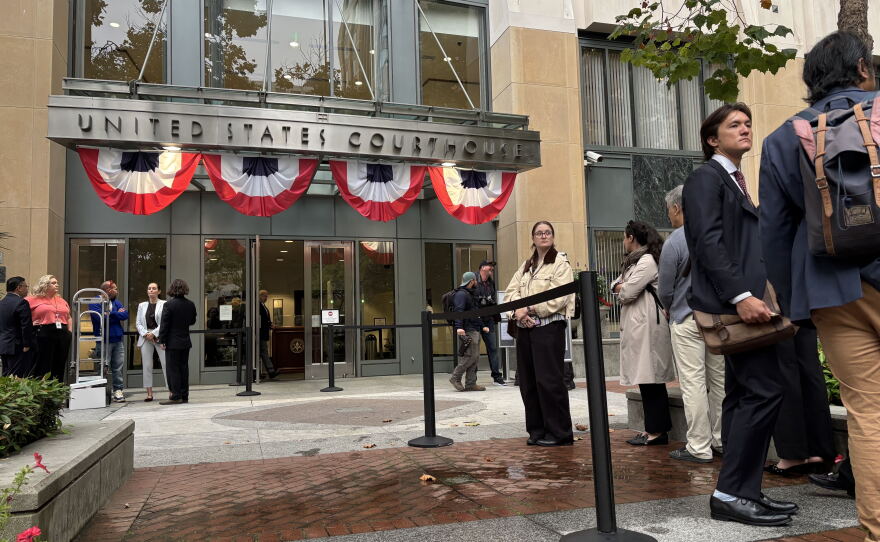 People line up outside the Oakland, California federal courthouse ahead of opening arguments in the trial that four state attorneys general are bringing against Meta Platforms, Inc.