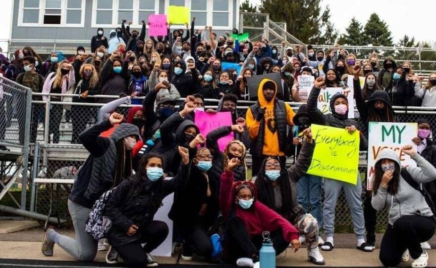 Students pose for photos during a walkout at Tartan High School in Oakdale, Minn.