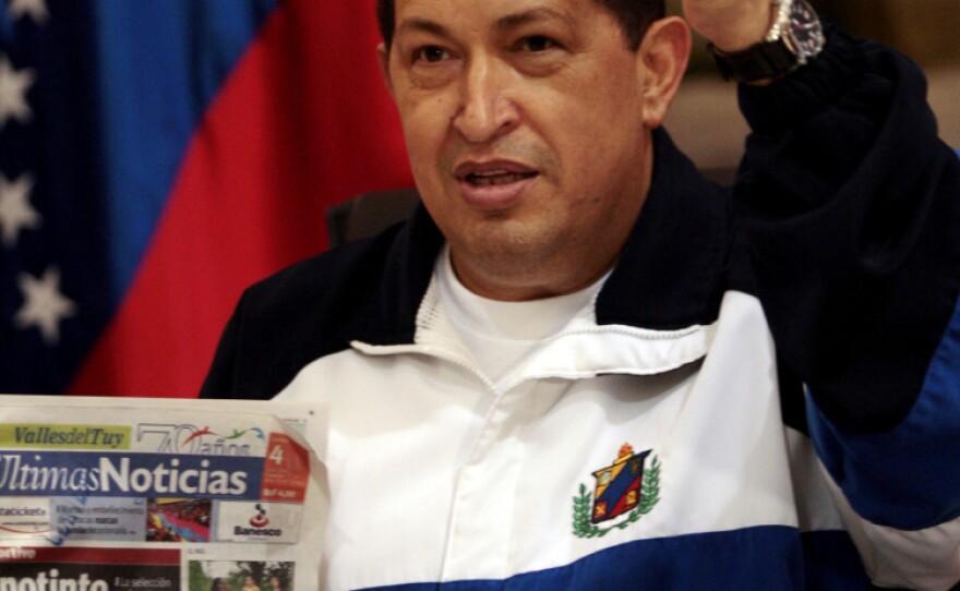 Chavez raises a fist as he holds a copy of a newspaper in a Caracas airport on July 4, after returning from Cuba where he had surgery to remove a cancerous tumor.