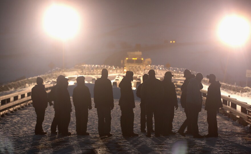 Military veterans protesting the pipeline stand opposite police guarding a bridge at the edge of the Standing Rock Sioux Reservation on Dec. 1, 2016.