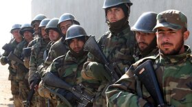 Afghan soldiers in training prepare to run a mock raid on a house. To speed recruits through their training, it has been cut from 10 weeks to eight.