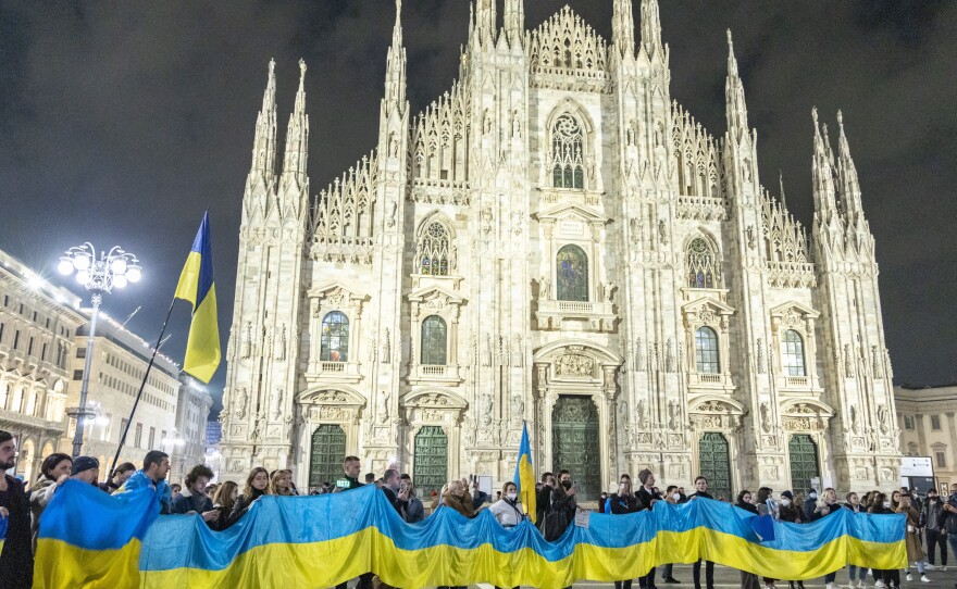 People hold a large flag of Ukraine in Duomo Square, Milan, Italy on Thursday.