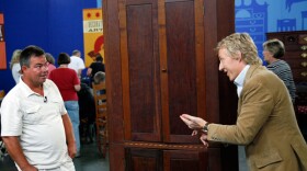 The owner (left) of this Kentucky corner cupboard - at one time destined to be burned and thrown away - discovers its true worth at ANTIQUES ROADSHOW in Louisville, Kentucky. Appraiser Leigh Keno of Leigh Keno American Antiques observes that the cupboard is made with locally grown wood, adding to its Kentucky flavor and appeal, and declares its value at $8,500.