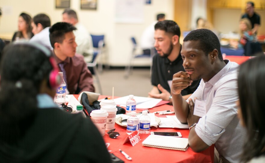 Teacher and consultant Yannick Kpodar, center, engages with students at a Braven event at San Jose State University.