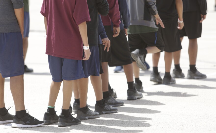 Boys 10 to 17 years old stand outside a government-contracted youth shelter in Brownsville, Texas. Ninety percent of the residents traveled to the United States alone seeking protection; the remainder were separated from their families at the border under a controversial new policy by the Trump administration.