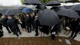 People wishing to pay their respects wait in the rain during the graveside service for Nancy Reagan at the Ronald Reagan Presidential Library, March 11, 2016 