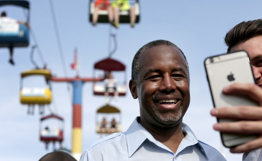 Republican presidential candidate Ben Carson poses for a photo with a fairgoer at the Iowa State Fair earlier this month.