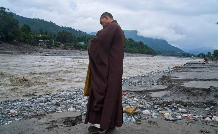 A Buddhist monk offers prayers for the departed soul of the victims of flash flood on the bank of Trishuli river in Devighat, Nuwakot district, Nepal, Saturday, Sept. 5, 2026.