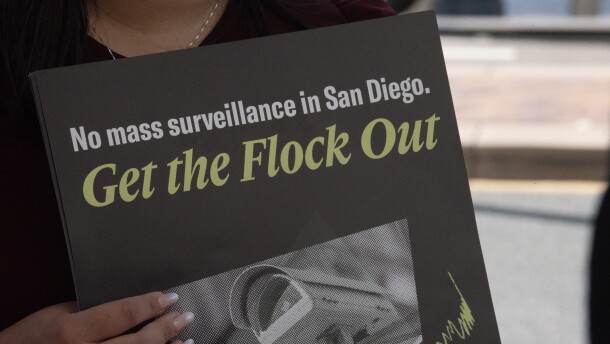 A protester holds a sign at a press conference announcing a lawsuit over the city of San Diego's use of Automated License Plate Reader technology on Sept. 30, 2026.
