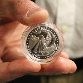 Christopher Polentz holds a coin featuring his design on Thursday, June 4, 2026.