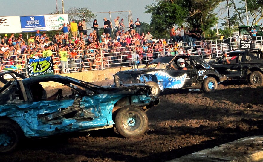 Travis Moyer (center) drives the car that he built for the demolition derby in Kansas.