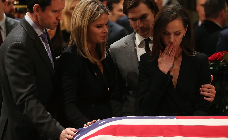 Jenna Bush Hager and her sister Barbara Bush stand with the husbands Henry Chase Hager, left, and Craig Coyne as they pay respect in front of the casket of the late former President George H.W. Bush as he lies in state in the U.S. Capitol Rotunda Tuesday in Washington, D.C.