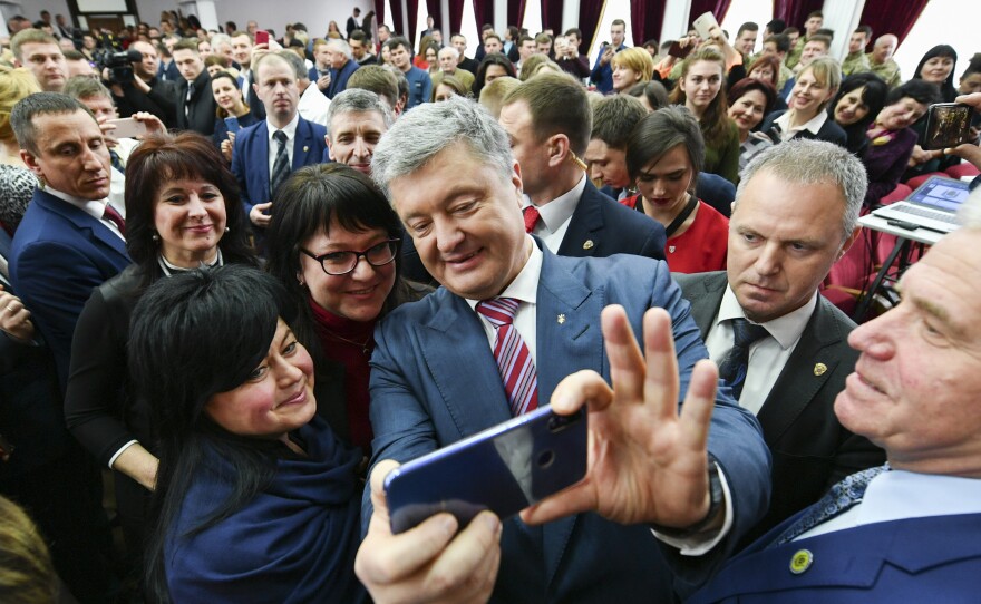Ukrainian President Petro Poroshenko takes a selfie with students in Kiev, Ukraine, on March 25. He is struggling for second place against veteran politician Yulia Tymoshenko.