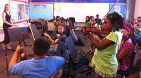 Laura Smith, a music teacher for San Diego Unified, watches as Raynisha Fields, 9, performs a solo in her fourth grade orchestra class at Zamorano Elementary School, Oct. 17. 2011.