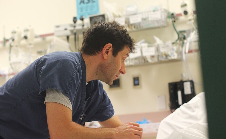 While repairs continue in the basement below, Dr. William Goldberg talks to a hospital patient who reports flu-like symptoms.