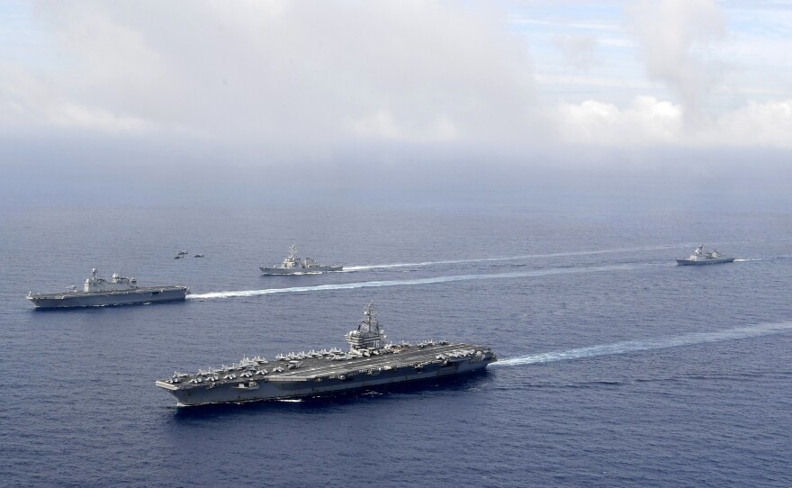 FILE - In this photo provided by South Korea's Defense Ministry, U.S. nuclear-powered aircraft carrier USS Ronald Reagan, second from left, and South Korea's landing platform helicopter (LPH) ship Marado, left, sail during a joint military exercise at an undisclosed location, June 4, 2022.
