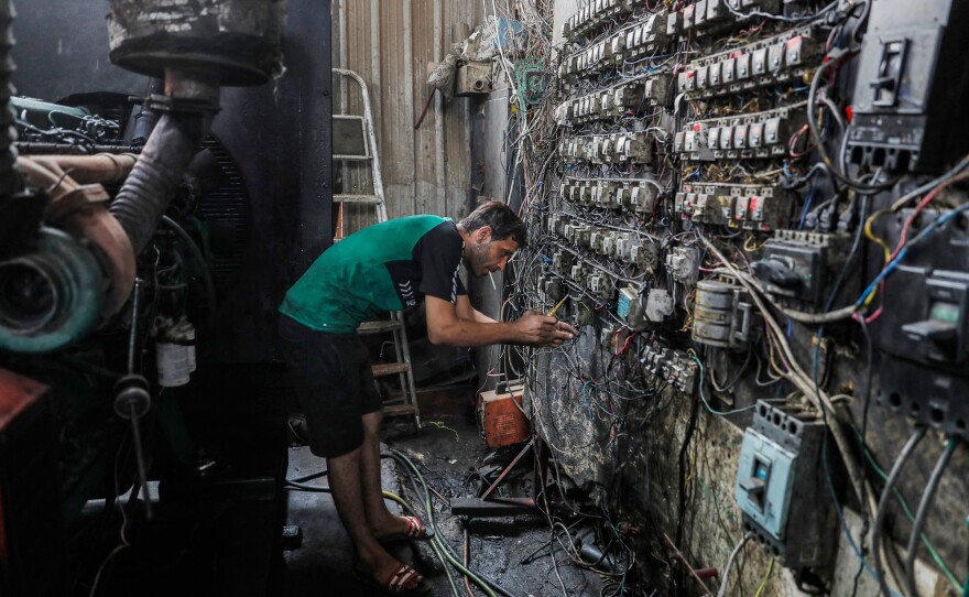 A technician controls an electric switch board connecting homes to privately-owned electricity generators in a suburb of Baghdad on June 30, 2021 as the national electric grid experienced outages amidst a severe heat wave.