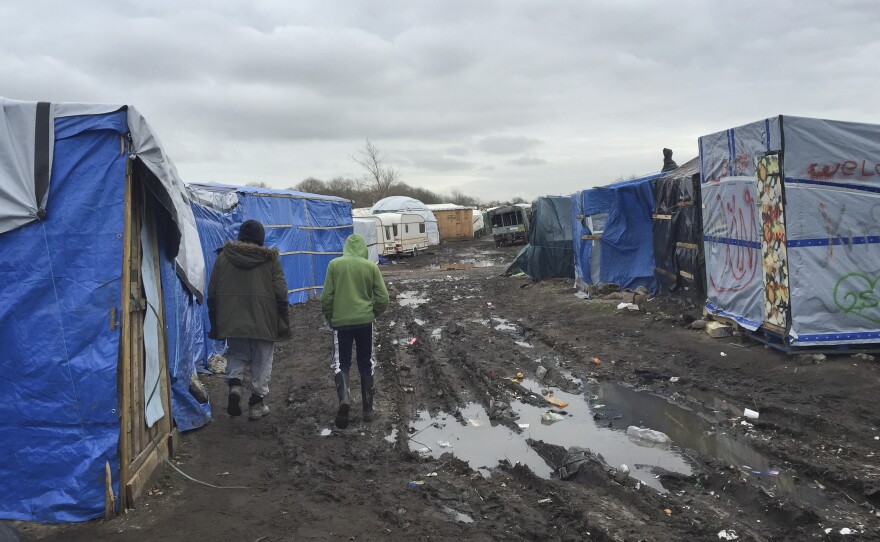Amran, an unaccompanied minor from Afghanistan, at right, walks in the camp known as the Jungle with 35-year-old Farid Hamdan, a father of four, also from Afghanistan. "My heart is saying help him because he's only a kid," says Hamdan. "He has nobody else here to look after him." There are 300 to 400 children staying in the Jungle.
