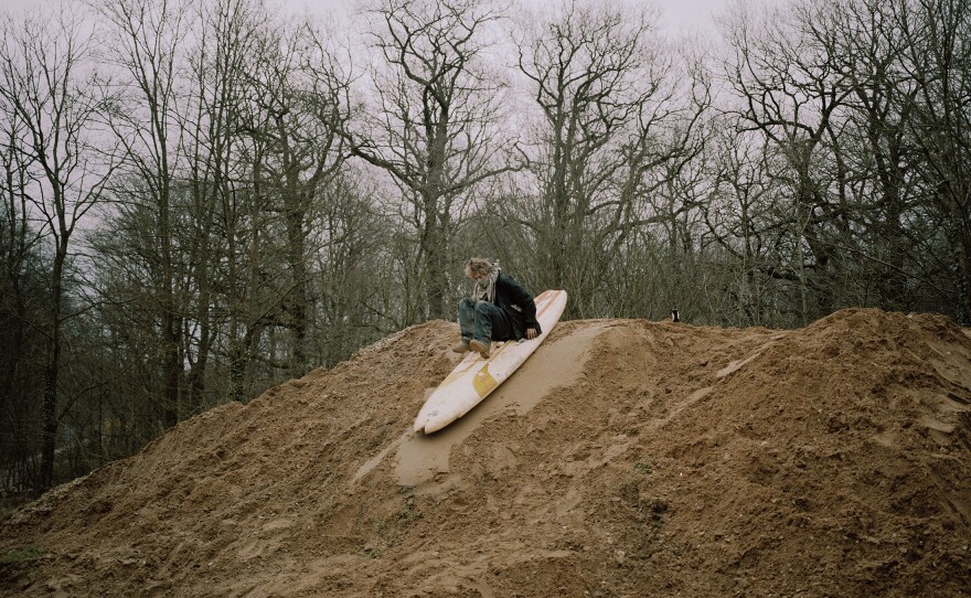 Hole surfs down a pile of mud. There is a lot of downtime between actions, and activists must find their own entertainment.
