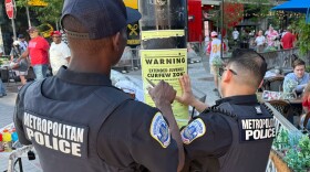 Washington D.C. Metropolitan Police officers place signage on a light pole informing the public that the area near the Nationals Park is under designate targeted juvenile curfew zone for youth under the age of 18.