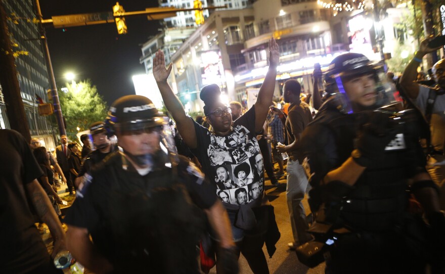 Protesters march Wednesday to protest the Tuesday shooting death of Keith Lamont Scott in Charlotte, N.C. Scott, who was black, was shot and killed by police officers, who say Scott was holding a gun and ignored instructions to drop it. Relatives and neighbors say he was holding a book.