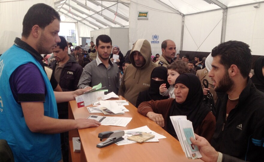 A picture taken with a smart phone shows Syrian refugees queuing at one of the many UNHCR (United Nations Refugee Agency) registration centers in Lebanon. At the same time that civil wars and the Ebola outbreak are plaguing countries in Africa, Syrian and Iraqi refugees are seeking help from agencies.