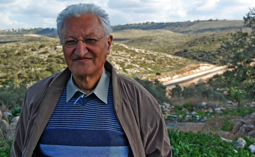 Palestinian-Israeli Hussein Jbara stands near the wall running between his Arab town in Israel and a nearby West Bank village where some of his relatives live.