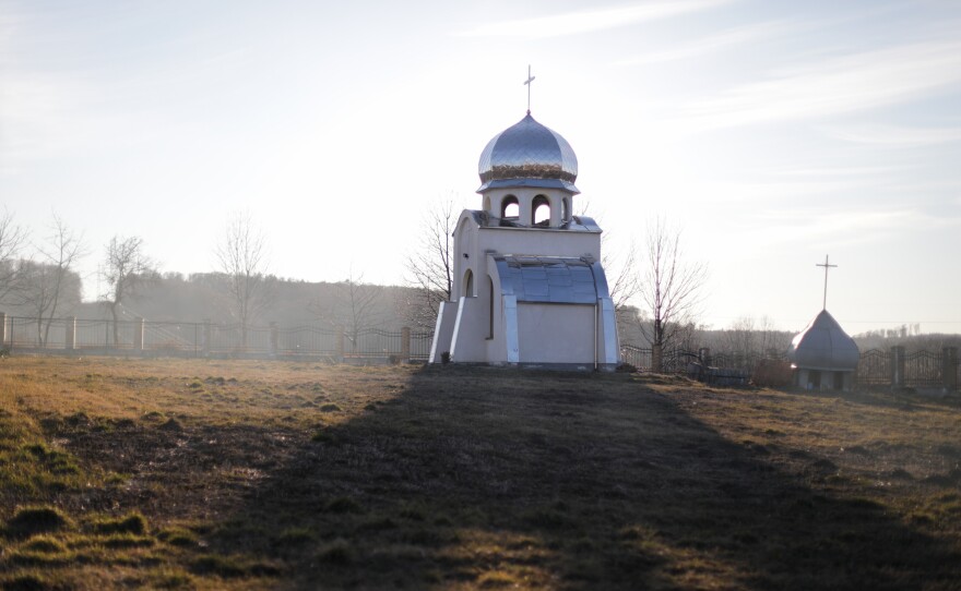 The sun sets on the grounds of the village church.