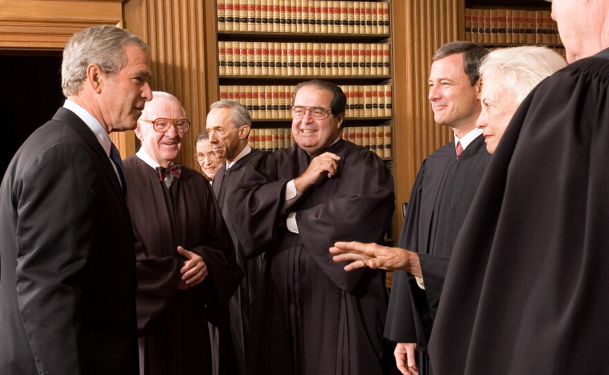 President George W. Bush (left) enjoys a light moment with members of the Supreme Court, including Justice Scalia (center) during the investiture ceremony of Chief Justice John Roberts in the Chief Justice's Conference Room in 2005.