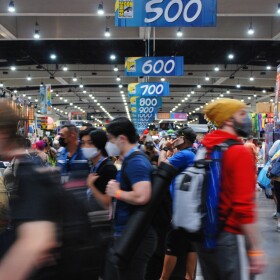 Hundreds of mask-wearing attendees throng the floor at Comic-Con 2022