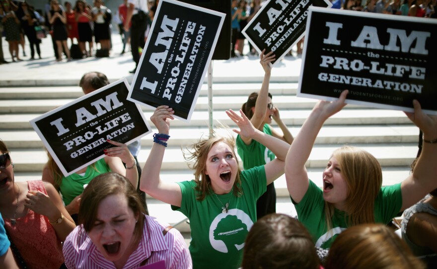 Anti-abortion advocates cheer in front of the Supreme Court on June 30 after hearing the ruling that some for-profit companies can refuse to offer contraceptive coverage on religious grounds.