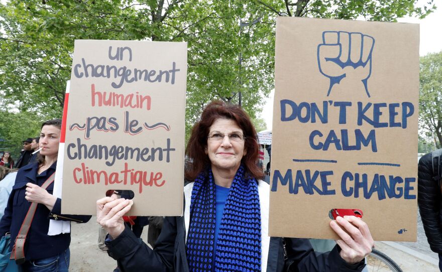 People take part in the March for Science in Paris. The sign reads: "A human change, not a climate change"