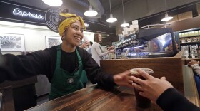 Barista Sarah Dacuno serves a customer at a Starbucks, commonly referred to as the original Starbucks, in the Pike Place Market in Seattle Tuesday, May 29, 2018. 
