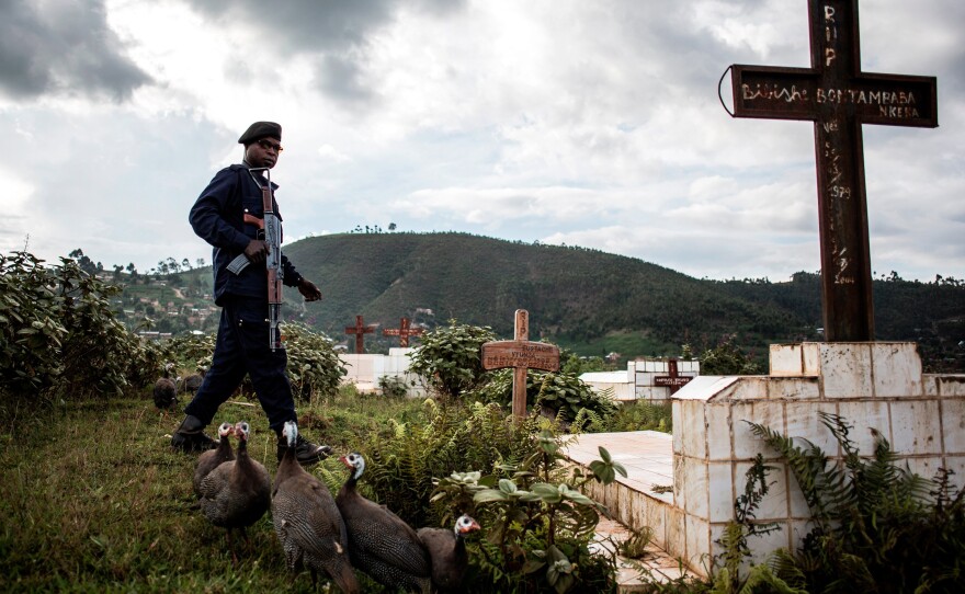 A police officer stands guard at a cemetery in Butembo during a funeral for people who died of Ebola. Many burial teams in Democratic Republic of the Congo have been attacked by hostile residents.