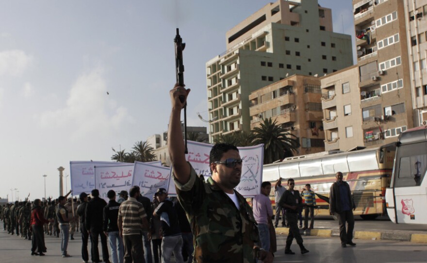 A Libyan rebel fires into the air while taking part in a military parade in Benghazi. Optimism in the rebel stronghold has turned to fear for some, as the crackle of shooting — celebratory, or to settle a score — has become a constant in the city.