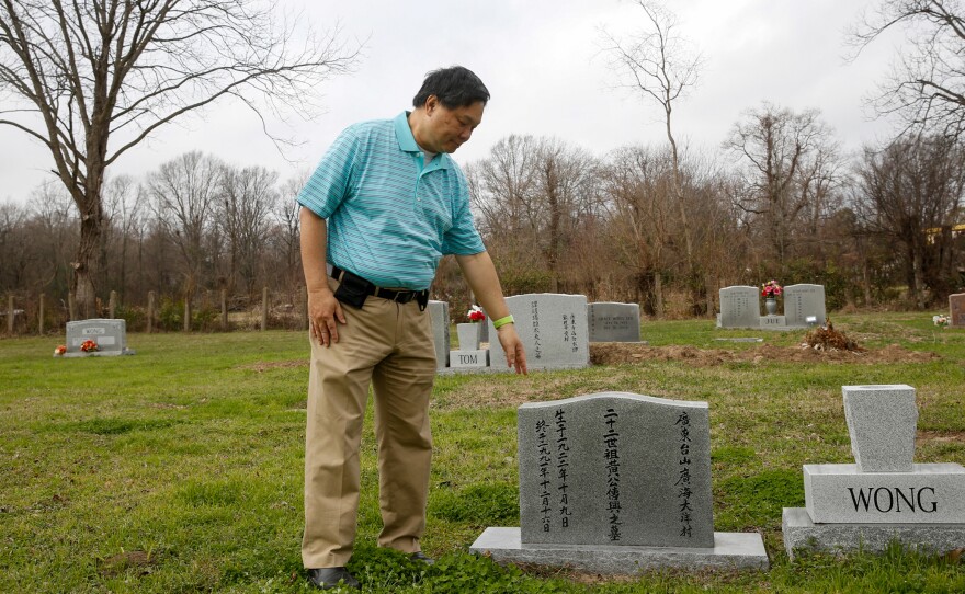 Raymond Wong (top) visits the gravesite where his parents are buried in Greenville, Miss. Wong's parents are buried in the Chinese cemetery, right across from an African-American cemetery. His family has long been part of a thriving, but separate, Chinese community.