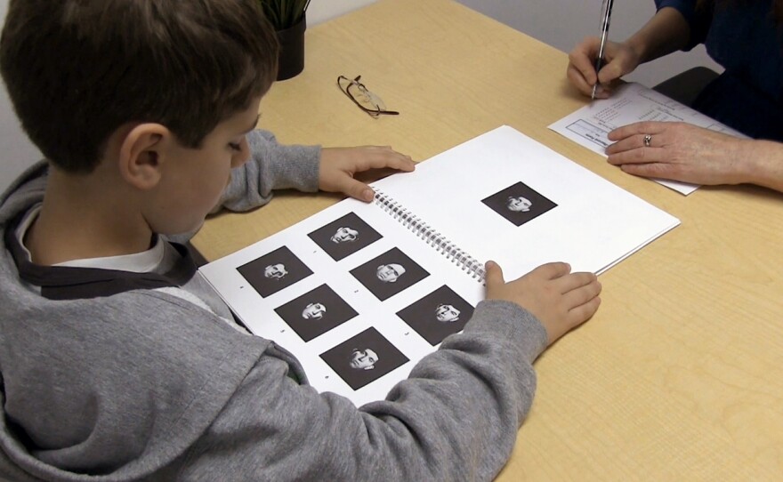 A child takes a facial recognition test in which he is asked to match the face on the top to one of the faces on the bottom.