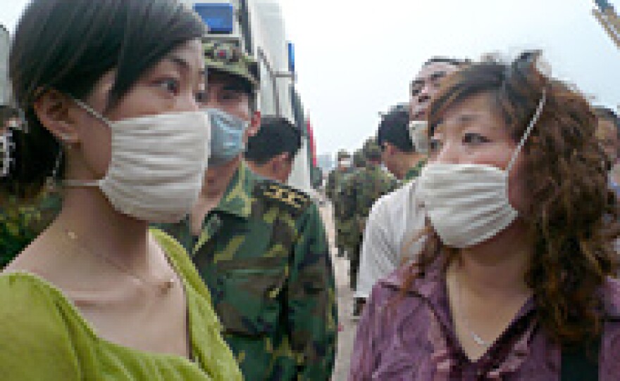 With Liu Deyun trapped inside a toppled building, his daughter, Liu Yuanyuan (left), and wife, Chen Xian Hui, await word of his fate.