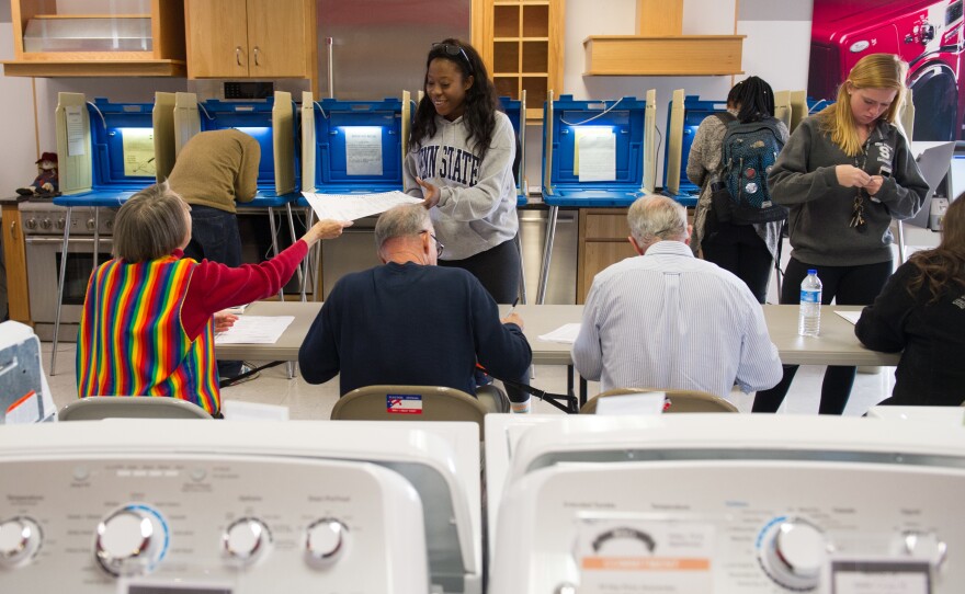 Voters cast their ballots in a polling location inside Mike's TV and Appliance in State College, Pa., on Tuesday.
