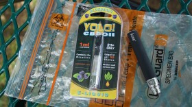 A Yolo! brand CBD oil vape cartridge sits alongside a vape pen on a biohazard bag on a table at a park in Ninety Six, S.C. , May 8, 2019. 
