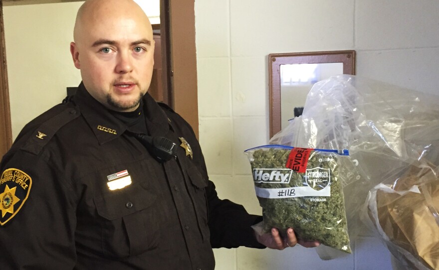 In the evidence room at the courthouse in Deuel County, Neb., Sheriff Adam Hayward holds up a 1-pound bag of marijuana confiscated during a recent traffic stop.