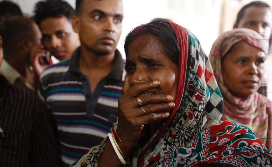 A relative of a victim cries as bodies are carried into a makeshift morgue at a hospital after a fire broke out Saturday at a packaging factory in Tongi industy area outside Dhaka, Bangladesh.