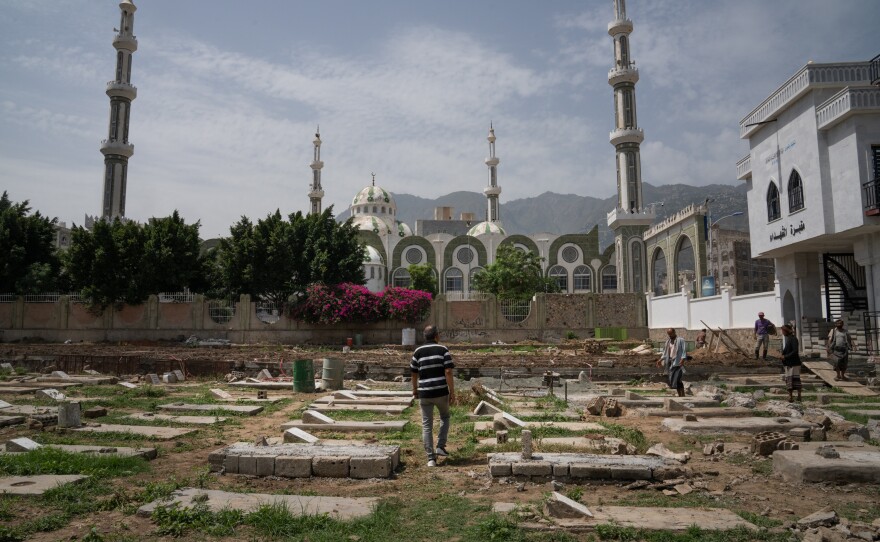 A man walks through a cemetery where there are graves for people who died during the war. The United Nations estimates that the conflict in Yemen caused over 377,000 deaths.