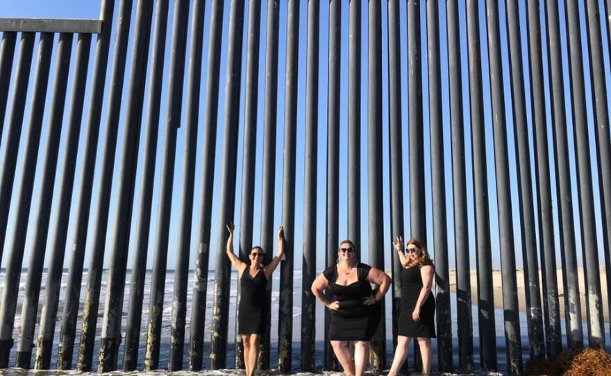 Eva Monroy, Anishka Lee-Skorepa and Elena Galitskaia of Artistas Fronterizas stand in front of the border fence in Playas de Tijuana, October 2018. 