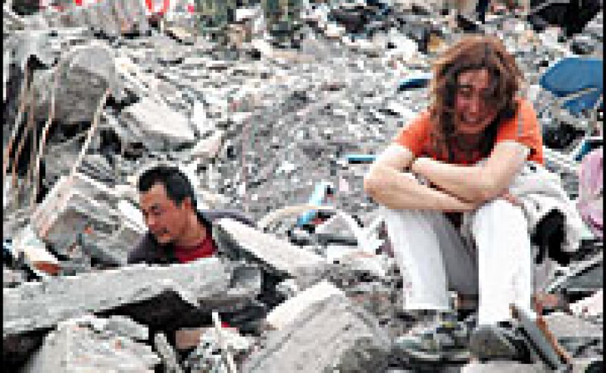 A Chinese couple in Mianyang city search for their son in the ruins of buildings that collapsed in Monday's earthquake. Mianyang City has suffered the most casualties in Sichuan province, where tens of thousands of people remain buried in ruins.